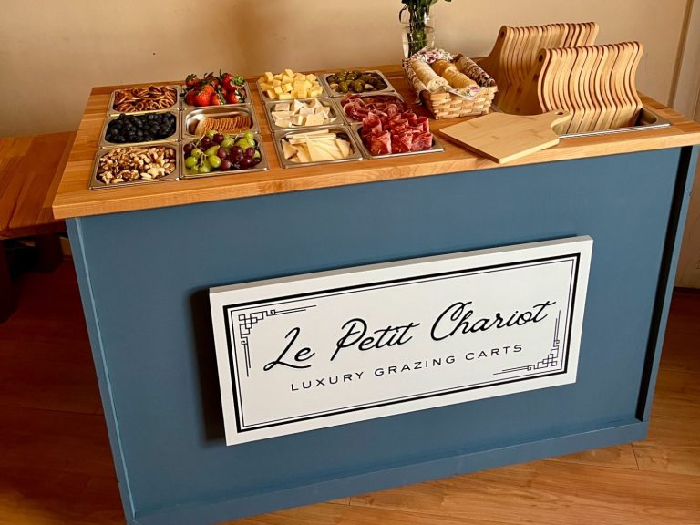 A selection of charcuterie foods inside the Le Petit Chariot luxury grazing cart with individual wooden serving boards A selection of fruits, nuts, cheeses, and charcuterie meats arranged on the Le Petit Chariot luxury grazing cart, ready for a party.